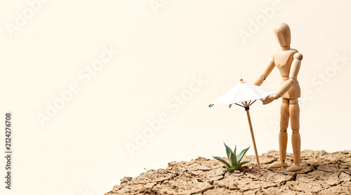 Heat wave climate change and heat anomaly protection with wooden figure holding umbrella over plant on dry ground with copy space for presentation