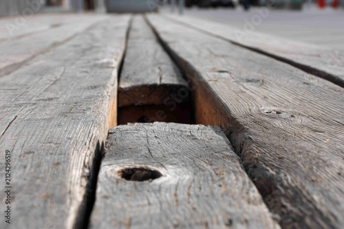 Wooden planks with a gap showing how it might be in an old market area during the day