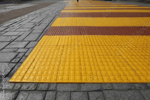 Yellow and brown tactile pavement on a city street for guiding people with vision loss