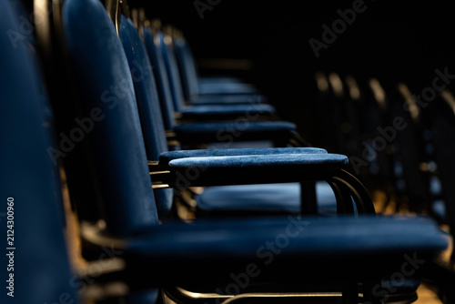 Obraz na płótnie Empty row of blue upholstered auditorium seats seen from close side angle, with