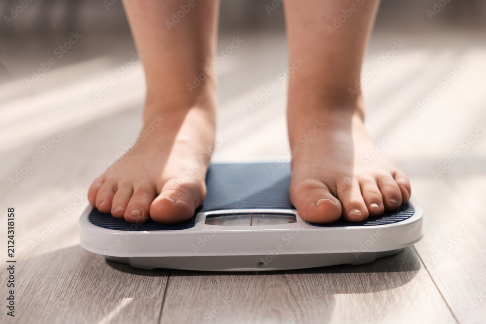 Fototapeta premium Overweight woman on scale at home, closeup