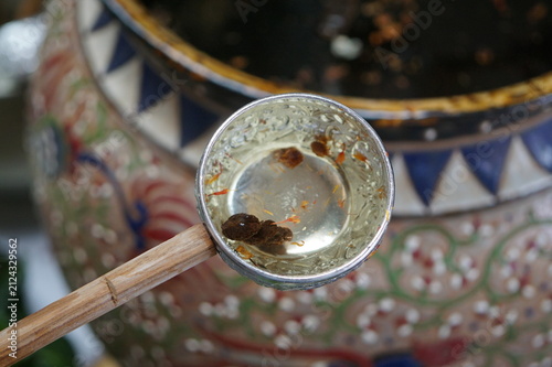 Canvas Print Traditional Buddhist water blessing ritual with a silver bowl.