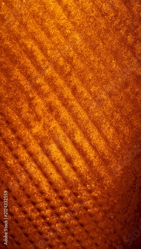Close-up of textured orange fabric with diagonal lines and patterns, showcasing intricate details and a rich, warm color tone suitable for various design applications