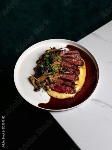 Canvastavla Elegant gourmet steak sliced and beautifully plated with colorful vegetables, rich sauce and refined garnish on a white plate, creating a premium restaurant presentation for culinary concepts