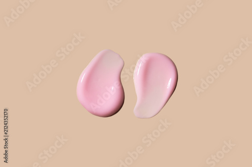 Pink cosmetic smears of cream texture on a beige background. Skin hydration