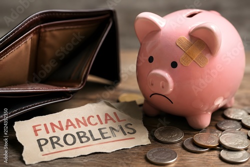 A sad piggy bank with a band-aid and an empty wallet for the concept of financial problems.