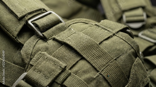 closeup of green tactical backpack with straps and buckles. military equipment and army gear concept. canvas texture with webbing. outdoor survival, airsoft, hunting. banner, website header.