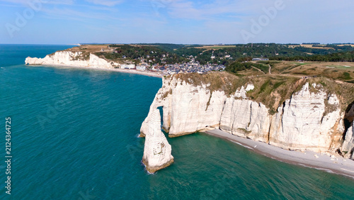 Картината върху платно Aerial view of a grassy headland with cliffs overlooking deep blue coastal water