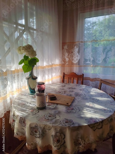 Rustic breakfast with coffee,egg,bread,jam and fresh flower in vase on countryside veranda table in the early morning,sunrise time
