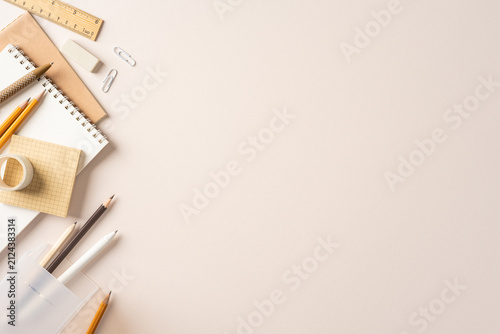 Back to school flatlay with beige stationery, pencil and notebook on an organized study workspace