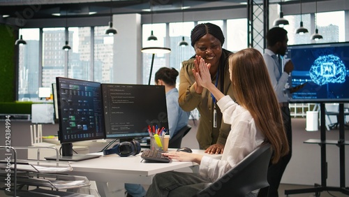 Fotografía Happy manager praises an intern with encouraging words and a congratulatory high five, giving positive feedback, motivation and support to a young female engineer after progress at work