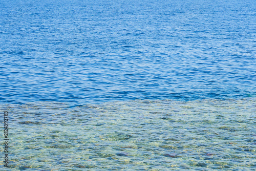 Crystal Clear Blue Sea Water Over Rocky Seabed, Tropical Coastal Background with Copy Space