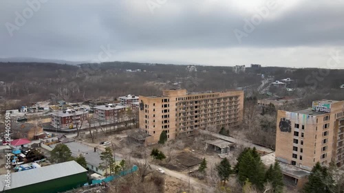 Aerial drone footage of the abandoned Sadgorod Mud Treatment Clinic in Vladivostok, Russia, showing old abandoned buildings and remaining forest surrounding the former clinic grounds.