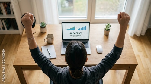 Overjoyed Remote Worker Celebrating Success with Business Growth Charts on Laptop Screen at Home Office Desk