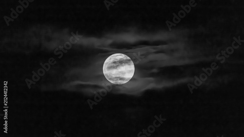Foto Full moon in the night sky with clouds