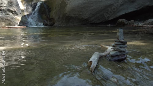 Zen Steine Stapel im fliessend Gewässer mit Wasserfall im Hintergrund - Natur und Entspannung