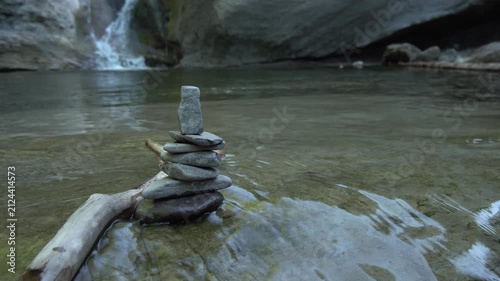 Zen Steine Stapel im fliessend Gewässer mit Wasserfall im Hintergrund - Natur und Entspannung