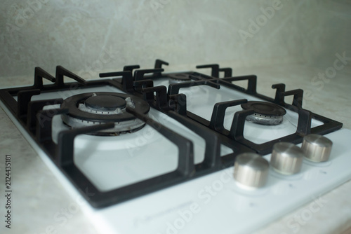 Modern built-in gas hob stove on white glass inside kitchen
