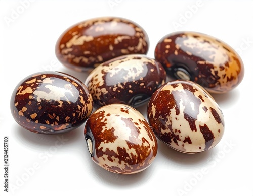 Six speckled, kidney-shaped beans scattered across a clean white background