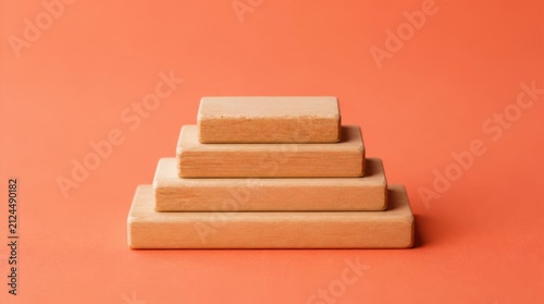 Wooden blocks stacked in a pyramid shape on a bright orange background