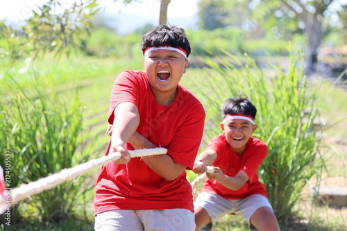 Foto Two groups of children compete in tug-of-war at an Indonesian Independence Day commemoration event held on a field