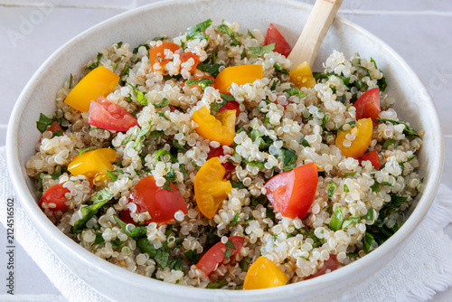 Close-up of a bowl of homemade tabbouleh made with quinoa, tomatoes, mint, and parsley.