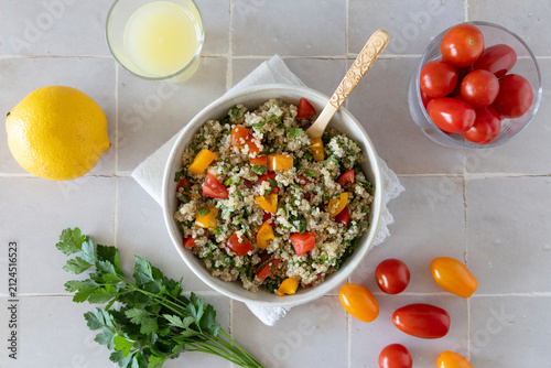 Close-up of a bowl of homemade tabbouleh made with quinoa, tomatoes, mint, and parsley.