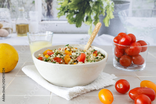 Close-up of a bowl of homemade tabbouleh made with quinoa, tomatoes, mint, and parsley.