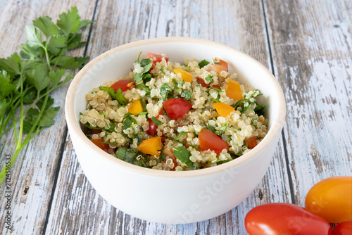 Close-up of a bowl of homemade tabbouleh made with quinoa, tomatoes, mint, and parsley.
