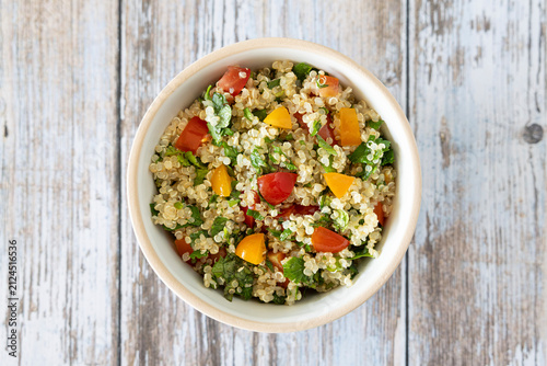Close-up of a bowl of homemade tabbouleh made with quinoa, tomatoes, mint, and parsley.