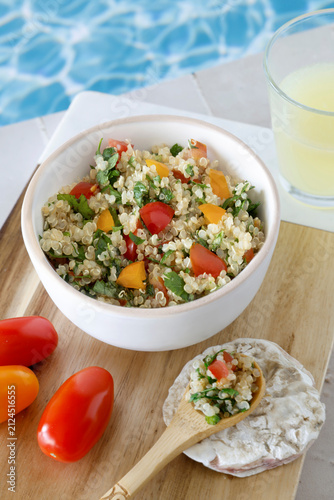 Close-up of a bowl of homemade quinoa tabbouleh by the side of a swimming pool