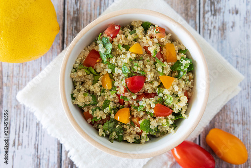 Close-up of a bowl of homemade tabbouleh made with quinoa, tomatoes, mint, and parsley.