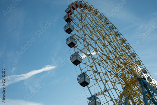 Obraz na plátne Ferris wheel captivates visitors at amusement park under bright sky
