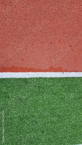 Red rubber playground, red running track, green artificial turf, white lines, rubber flooring, texture