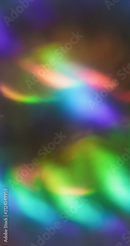 Blur crystal kaleidoscope. Bokeh glow. Pink green blue color radiant illuminated rainbow flash on abstract optical art black luminous background.