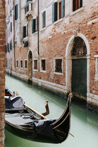 Photography Traditional gondola on a quiet canal in Venice, Italy