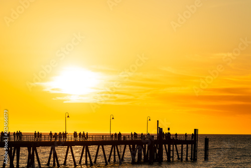 People strolling along Glenelg Jetty during summer sunset, Adelaide, SA