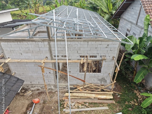 Construction Site: Concrete House With Metal Roof Frame And Bamboo Scaffolding