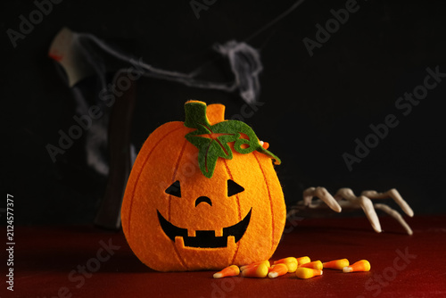 фотографія Pumpkin made of felt and tasty Halloween candy corns on grunge background, close