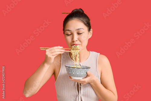 Young Asian woman eating ta...