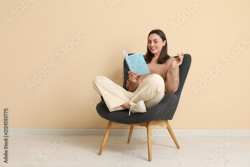 Young woman sitting on armc...