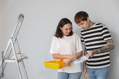 Young couple with paint color palettes doing repair in their new house