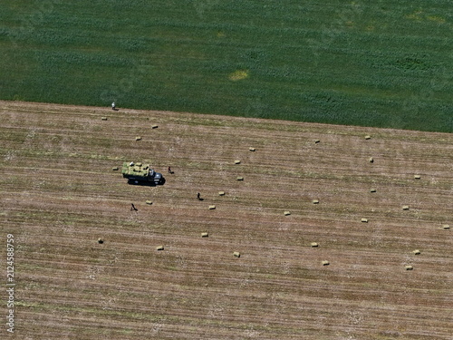 Collecting hay and grass in a large field. The view from the drone.