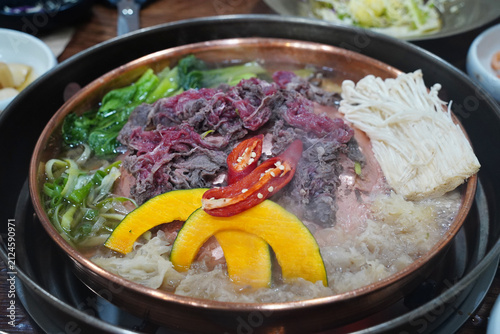 Sliced beef Bulgogi hot pot boiling on a traditional bronze pan with vegetables