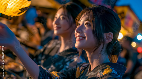 夜の夏祭りを楽しむ浴衣姿の女性たち

