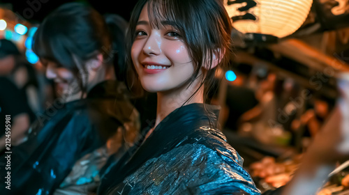 夜の夏祭りを楽しむ浴衣姿の女性たち

