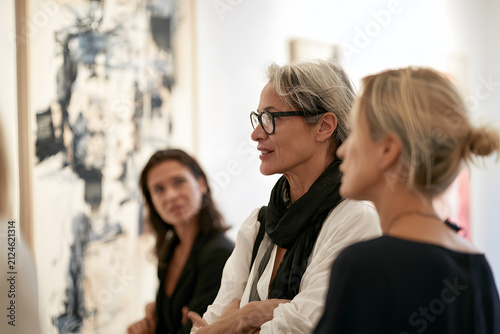 Art gallery opening event in Brera district with visitors engaging in conversation and appreciating artwork