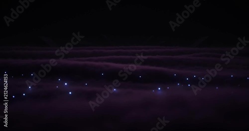 Glowing ethereal particles drift across dark purple clouds in this hypnotic cinematic motion video clip featuring vibrant light effects and mystical atmosphere for modern digital projects.