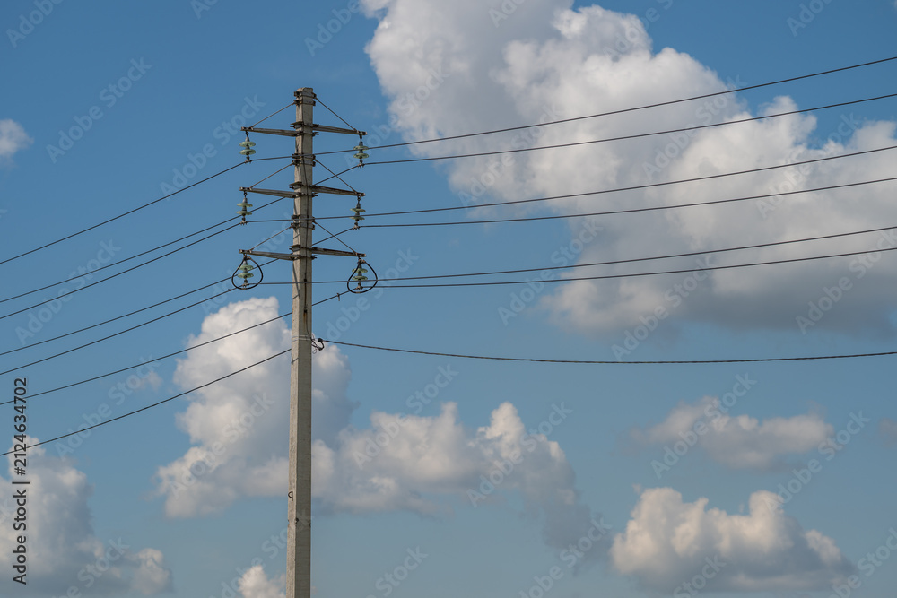 Obraz premium Majestic power transmission lines carve through the blue sky, connecting communities with energy and hope on a sunny day