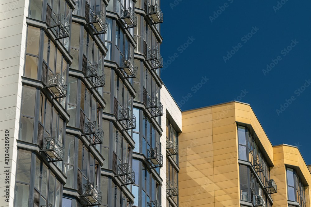 Obraz premium Buildings with balconies under a clear blue sky in an urban area during daytime